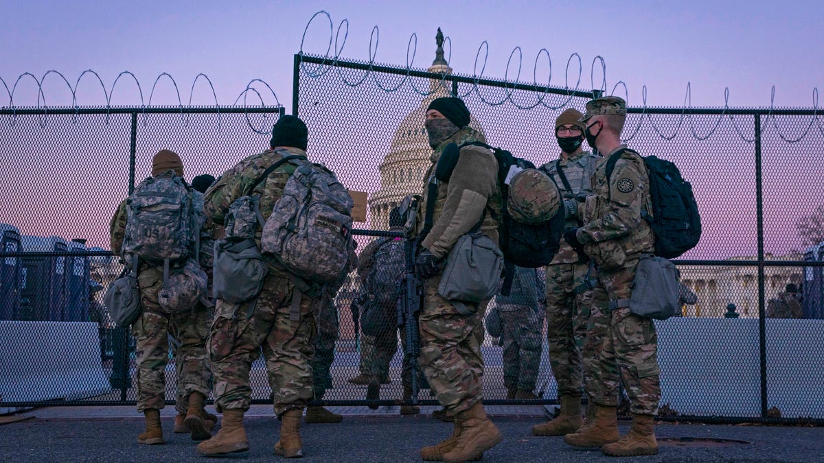 National Guard members enter barbed wire gate to protect the Capitol on Feb. 8, 2021, in Washington, D.C.