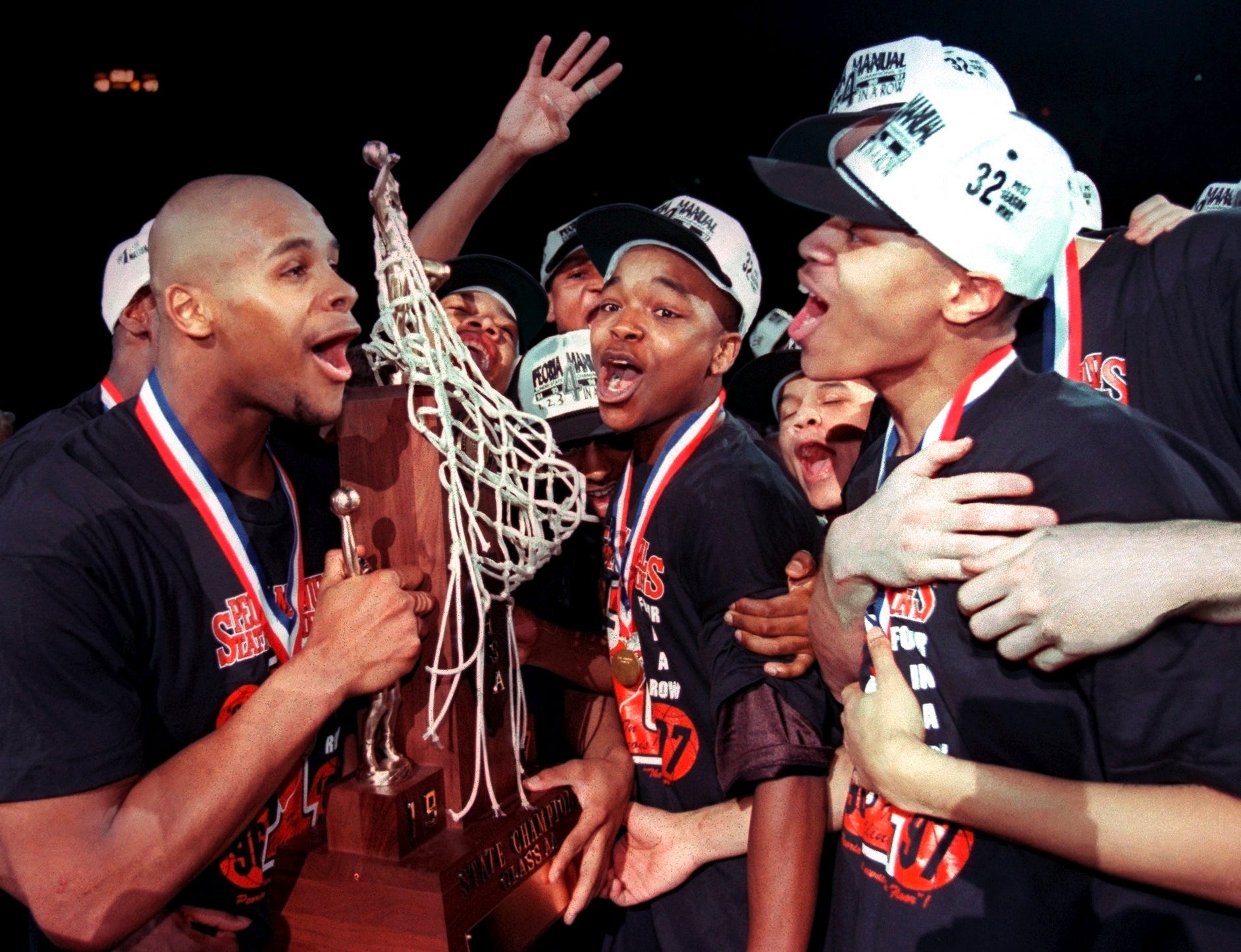 Sergio McClain, left, and the Manual Rams celebrate their fourth consecutive IHSA state boys basketball title in 1997 at Carver Arena in Peoria.