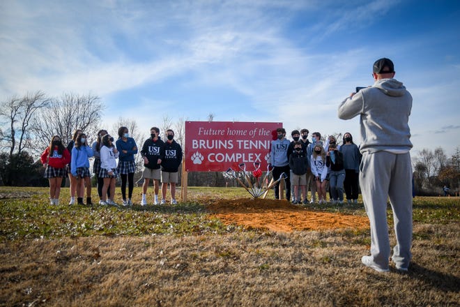 USJ tennis coach Ted Measley takes a photo of the Bruin tennis players in front of a sign just before the groundbreaking ceremony on the school's campus for a new tennis facility on Feb. 8, 2021.