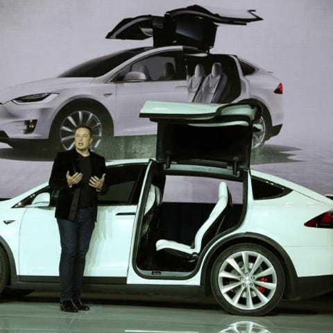 Tesla CEO Elon Musk next to a Model X electric spo