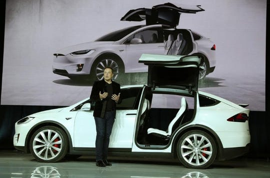 Tesla CEO Elon Musk next to a Model X electric sport utility vehicle during a presentation in California in 2015.