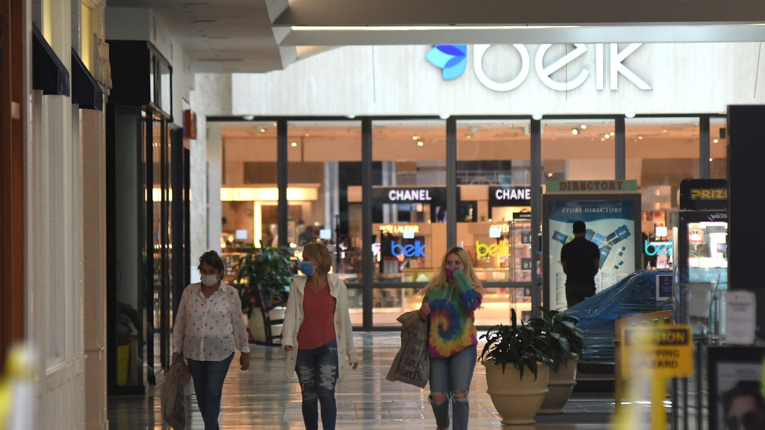 People walk some of the stores at Independence Mall with Belk in the background.