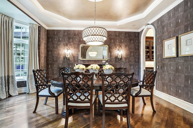 Leather wallpaper with white beads wraps the formal dining room. Striking wallpapers and light fixtures are themes the owners put through this house.
