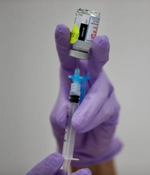 COVID-19 vaccine is transferred into a syringe at Wauwatosa City Hall on Thursday.