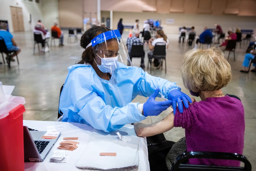 Brittnee Wiliams, a licensed practical nurse, administers a COVID-19 vaccine to Rachael Kantor of Palm Desert at a Riverside County vaccine clinic in Indio, Calif., on February 10, 2021.  