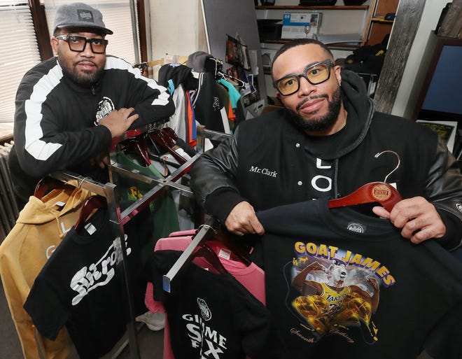 Frank Miller III, left, and Preston Clark, owners of 7th Floor Clothing, show off some of their apparel in their Akron office.