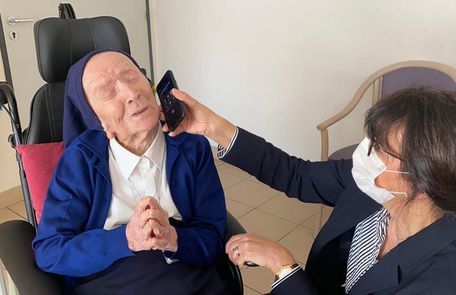 This photo provided by the Sainte-Catherine Laboure care home communications manager shows Lucile Randon, Sister Andre's birth name, speaking on the phone in Toulon, southern France, Thursday. Sister Andre, believed to be the world's second-oldest person, was celebrating her 117th birthday in modern style.