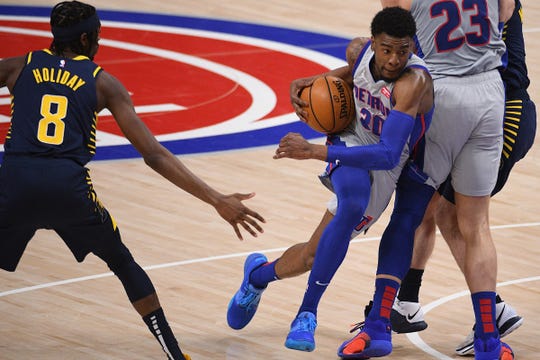 Detroit Pistons guard Josh Jackson (20) drives to the basket against Indiana Pacers guard Justin Holiday (8) during the second quarter at Little Caesars Arena in Detroit on Thursday, Feb. 11, 2021.