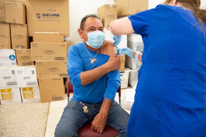 Armando Izaguirre, of Immokalee, has a bandage applied to his arm after receiving his COVID-19 vaccine during a Healthcare Network vaccination clinic, Tuesday, Feb. 9, 2021, in Immokalee.