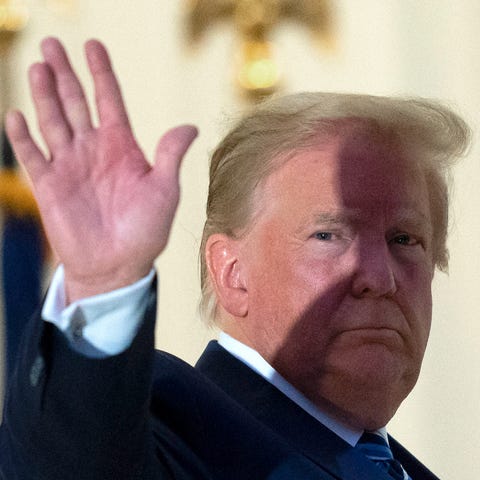 President Donald Trump waves from the Blue Room Ba