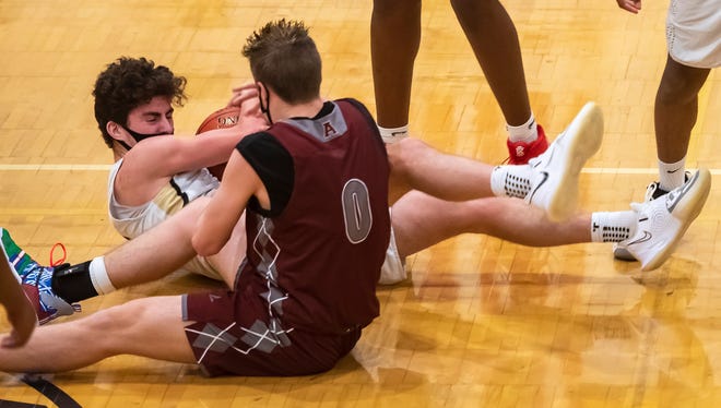 Quaker Valley's Will Dunda battles with Ambridge's Damon Astorino for a loose ball during their game Thursday at Quaker Valley High School in Leetsdale.