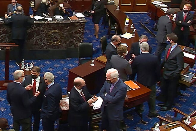In this image from video, Republican senators and staff talk on the floor after a vote on the motion to allow witnesses in the second impeachment trial of former President Donald Trump in the Senate at the U.S. Capitol in Washington, Saturday, Feb. 13, 2021. (Senate Television via AP)