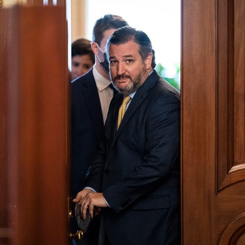 Sen. Ted Cruz, R-Texas, walks out of a meeting roo