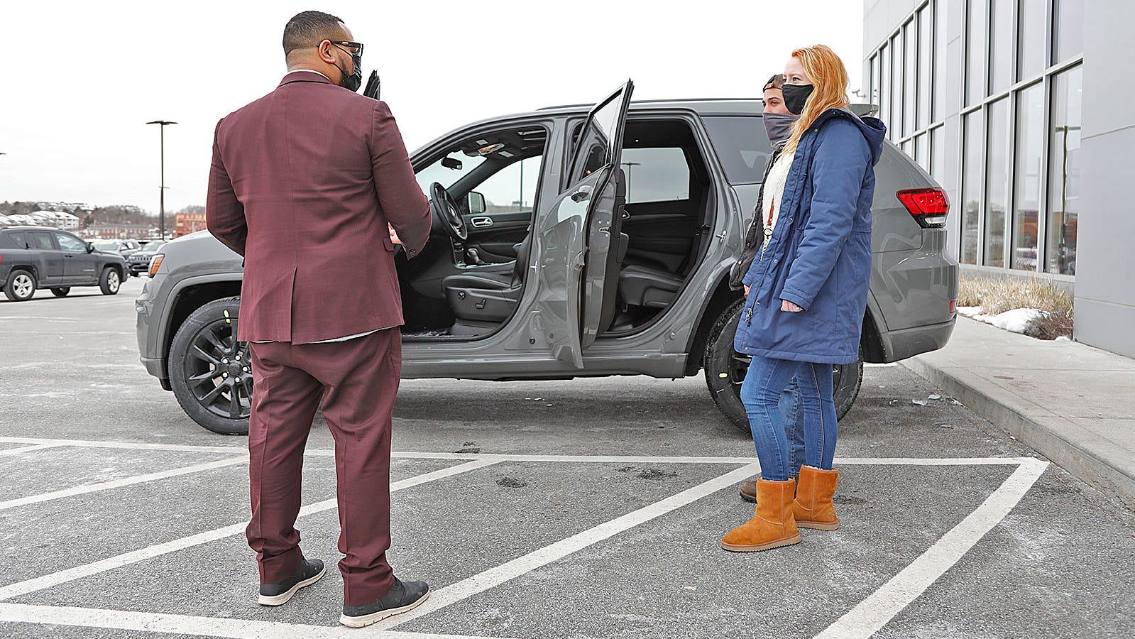 Sales Manager Rafael Mejia shows a new Jeep Grand Cherokee to customers Elisabeth and Nick Habeeb of Carver at the Quirk Chrysler Jeep in Braintree on Sunday Feb. 14, 2021.