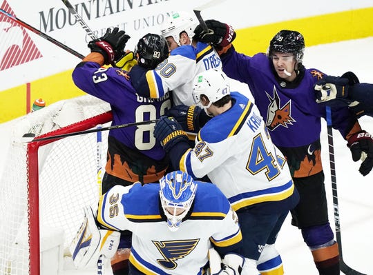 Feb 13, 2021; Glendale, Arizona, USA; St. Louis Blues center Ryan O'Reilly (90) goes after Arizona Coyotes right wing Conor Garland (83) in the first period at Gila River Arena. Mandatory Credit: Rob Schumacher-Arizona Republic
