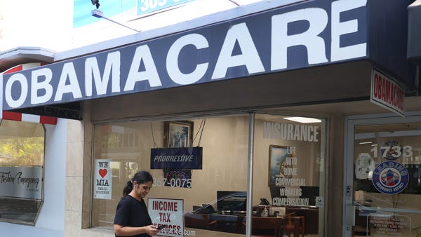 A pedestrian walks past the Leading Insurance Agen