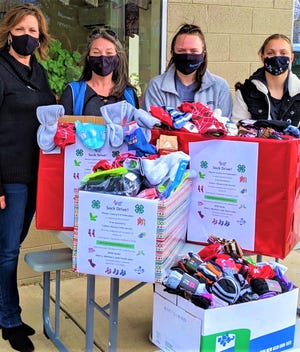 A sock drive organized by the Mason County 4-H Federation members, resulted in a collection of 787 pairs of socks which was donated to the Fulton-Mason Crisis Service for clients in crisis situations. 
Pictured from the left are: Joli Pierson, Mason County 4-H Program Coordinator; Julie Toney of Fulton-Mason Crisis Service; Madi Hofreiter and Alexandria Riviere, Mason County 4-H Federation members.