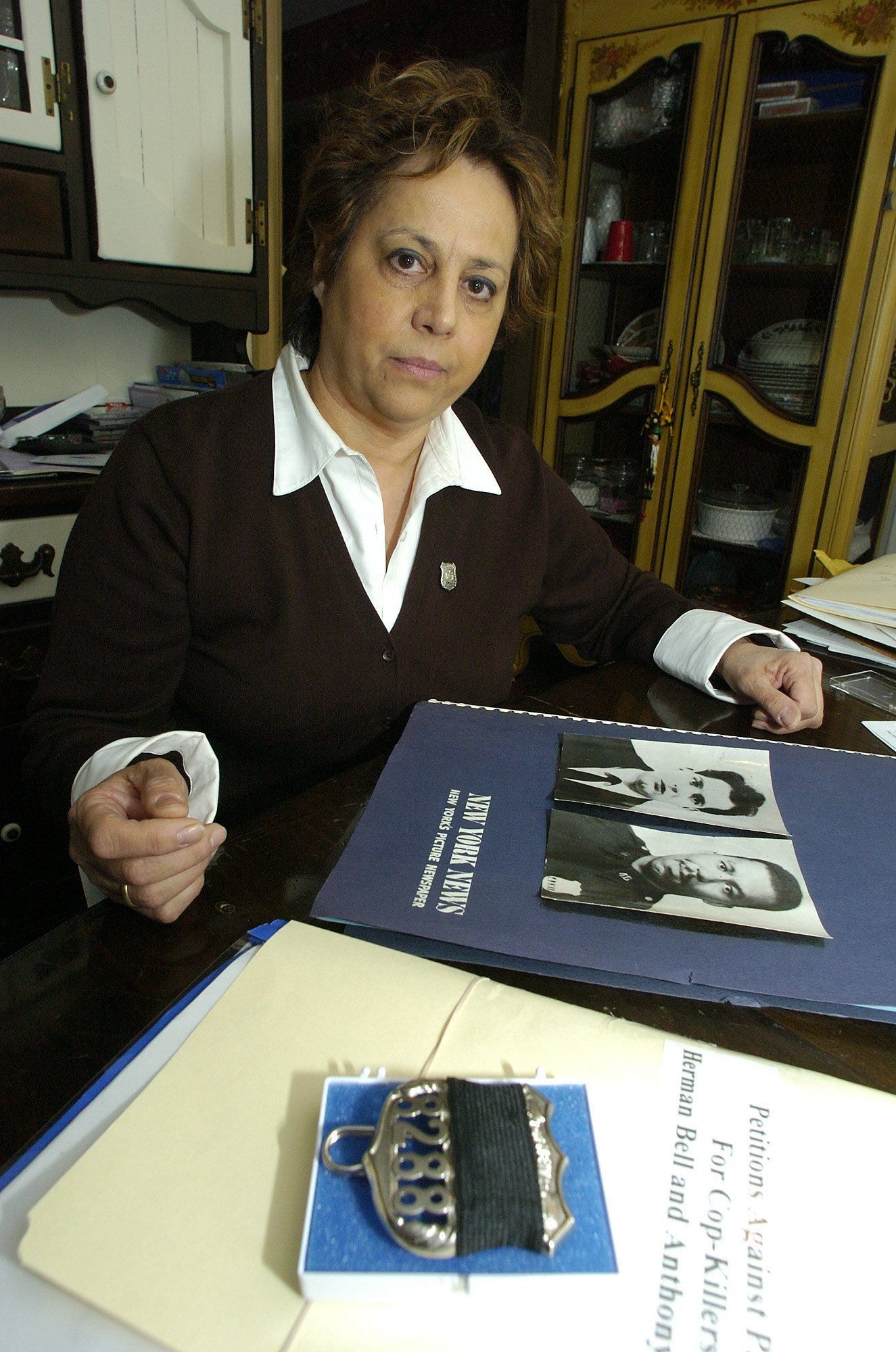 Diane Piagentini, widow of New York City police officer Joseph Piagentini, who was killed in 1971 by members of the Black Liberation Army, a violent offshoot of the Black Panthers, sits in her Deer Park, N.Y., home Thursday, Jan. 8, 2004, with photos of her husband. Piagentini is fighting the parole of her husband's killers.