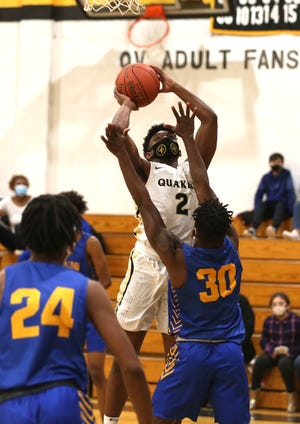 Quaker Valley's Malcolm Jordan (2) attempts a layup while being guarded by Lincoln Park's Daquan Bradford (30) during the first half Tuesday night at Quaker Valley High School.