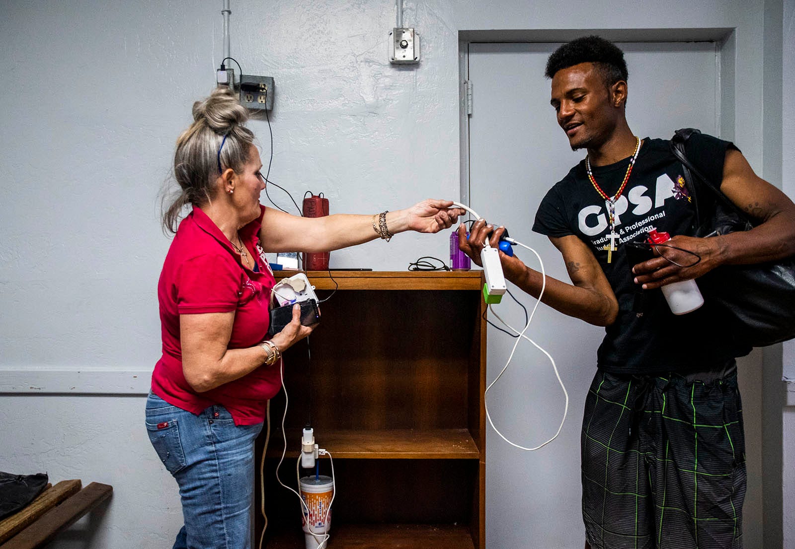 After sharing their past traumas and future goals, Darlene Carchedi tells friend Romeo Lopez she's proud of him as they charge their phones at the Andre House in Phoenix on Feb. 27, 2020.