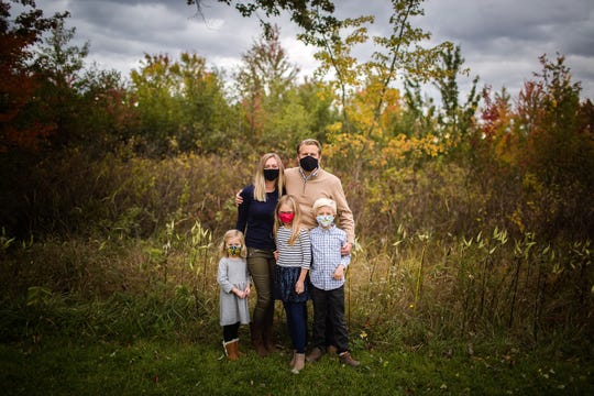 Abby Adair Reinhard, her husband Josh, and their three kids pose for a family photo in summer 2020.