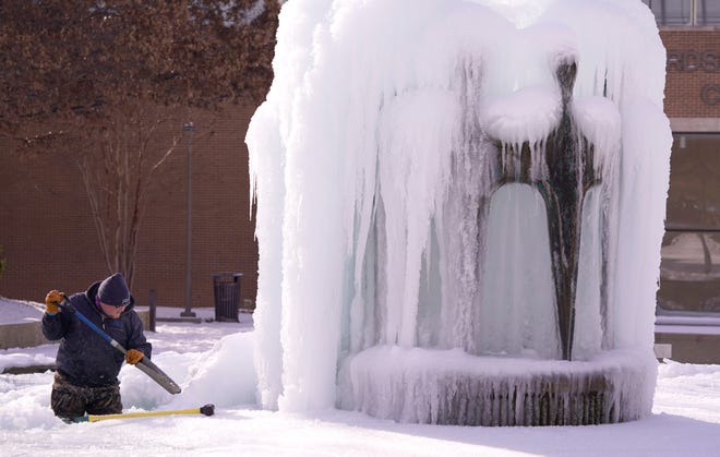 Kaleb Love, a worker in the city of Richardson, works to clean the ice from a water fountain on Tuesday, February 16 in Richardson, Texas.