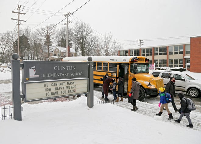 Students arrive at Clinton Elementary School by car, bus and on foot on Feb.18. School officials announced on Thursday that students in grades 6, 11 and 12, divided in two groups, will return to in-person learning on March 15 and March 18. Meanwhile, students in grades 7, 8, 9 and 10 will return on March 22 and March 25.