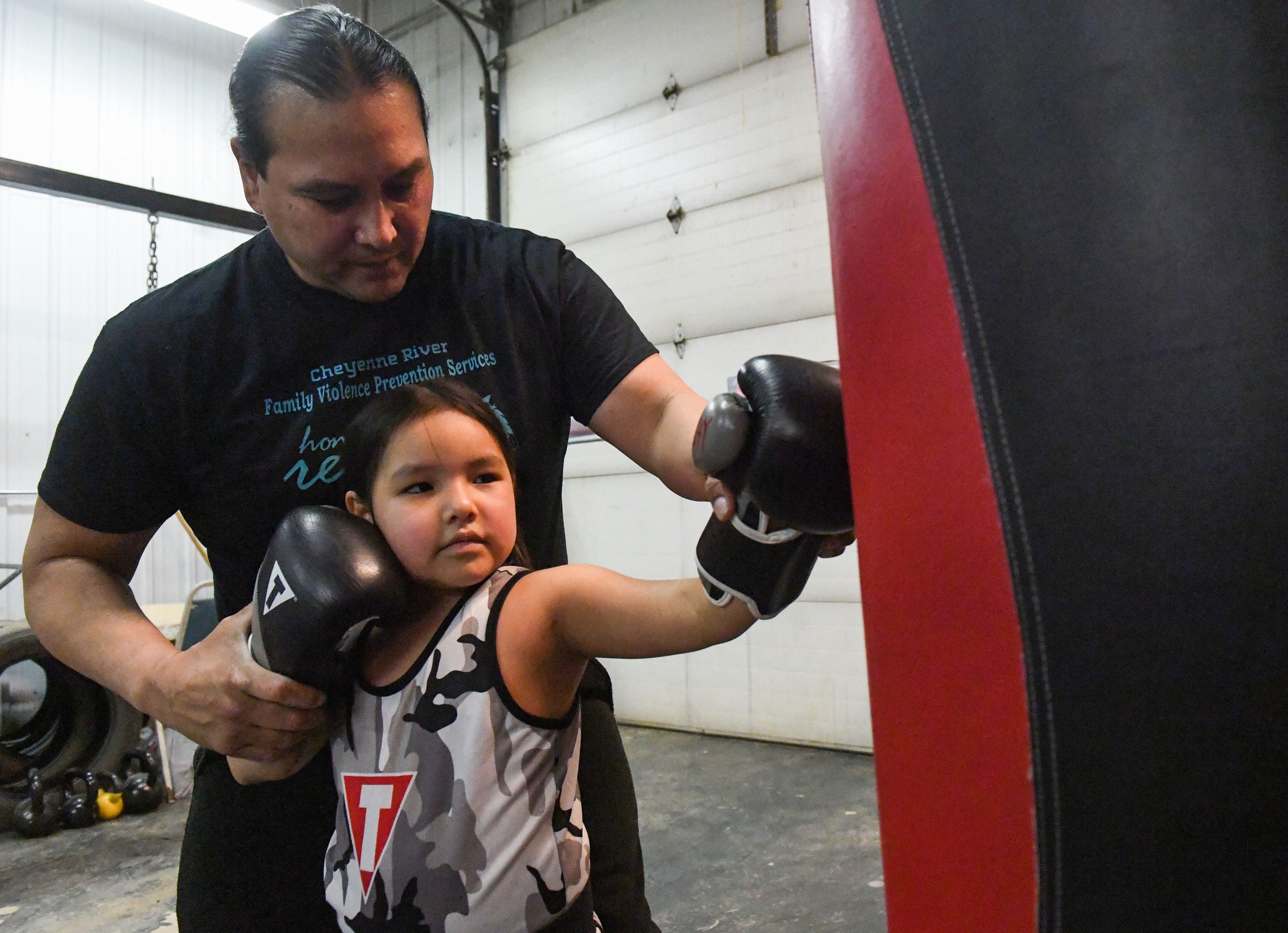 Joe Brings Plenty instructs his 6-year-old daughter, Sophie, how to jab at Wolves' Den Boxing in Eagle Butte, South Dakota, on Feb. 17.