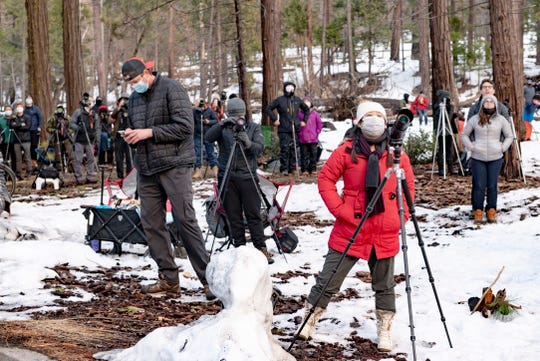 Mickie Lee of San Jose and other photographers watch the light change on Horsetail Fall in Yosemite National Park on Tuesday, February 16, 2021. Hundreds of photographers turn out for the annual phenomenon hoping to catch the fallÕs water as it passes through a narrow slit of rays from the setting sun in mid February. This was LeeÕs third attempt in as many days due to uncooperative weather.