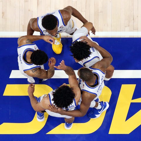 Pittsburgh Panthers players huddle on the court be