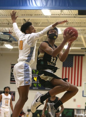 Quaker Valley's Markus Frank (13) goes airborne for a layup while being guarded by Lincoln Park's Joe Scott (10) during the second half Thursday night at Lincoln Park Performing Arts Charter School.