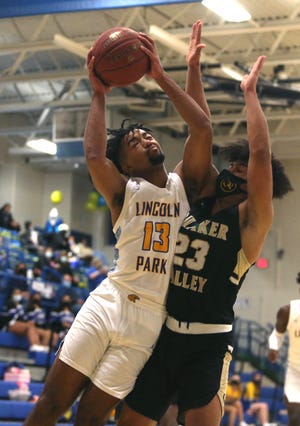 Lincoln Park's Elias Bishop (13) goes to the basket for a layup while being guarded by Quaker Valley's James Davis (23) during the first half Thursday night at Lincoln Park Performing Arts Charter School.