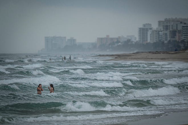 Los bañistas juegan con las olas en Delray Municipal Beach el 16 de febrero.