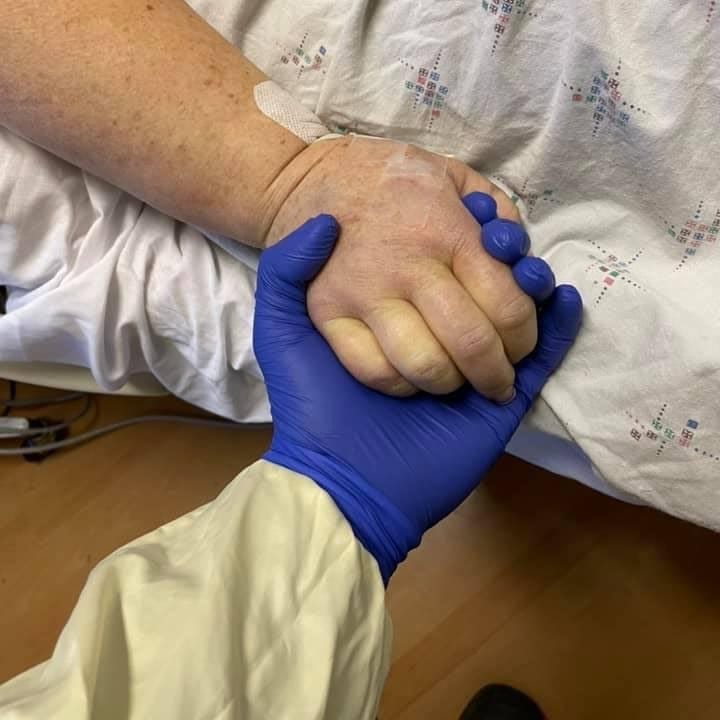 Nathanial Stephens holds his grandmother Judy Dover's hand.