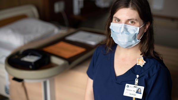 Nurse Amanda Baetsle stands for a photo in a room 
