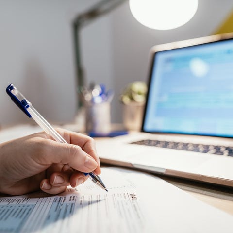 Working from home, woman fills out out tax form.