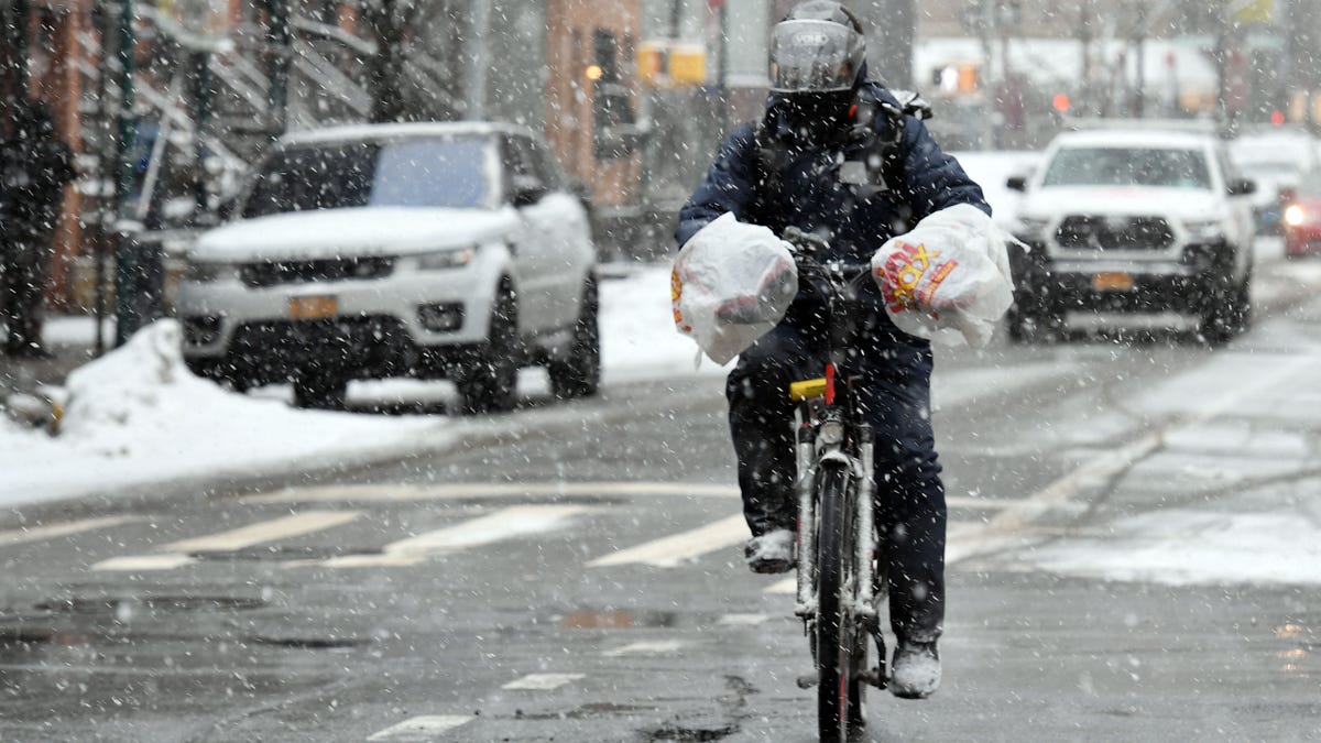 A cyclist rides through snow in the New York borough of Brooklyn during a winter storm on February 18, 2021.