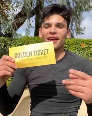 Ryan Garcia holds up a "golden ticket" worth a $5,000 donation from Gymshark to the High Desert Boxing Club in Victorville on Friday, Feb. 19, 2021.