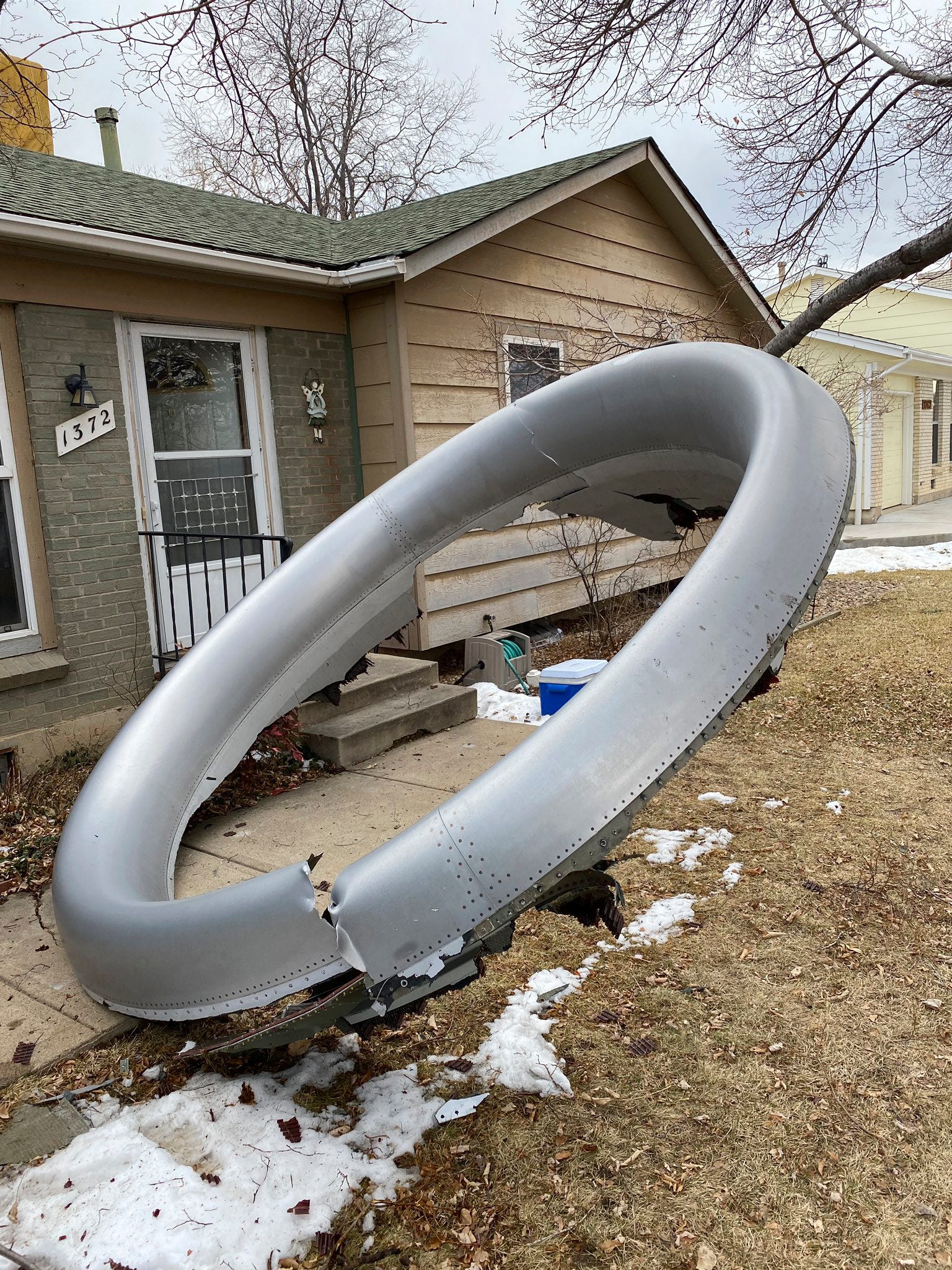 Debris is scattered in the front yard of a house in Broomfield, Colo.