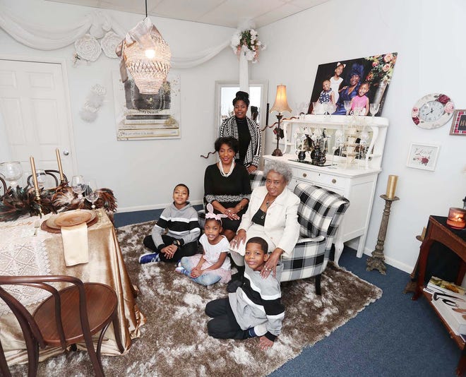 Renea Woods Baylor, center left, sits inside one of her tea rooms inside her downtown business the Tea Lady surrounded by her grandchildren Tyler Kirkey, 10, back left, TiaMarie Washington, 6, and Trevor Washington, 7, her mother Gertrude Overstreet-Robinson and her daughter Natasha Overstreet Saturday, Feb. 20, 2021 in Akron, Ohio. Baylor is the third of five generations of entrepreneurs in Northeast Ohio.