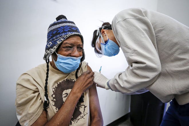Registered nurse Katherine Han delivers a COVID-19 vaccination to Lance Curtis, 65, in downtown Los Angeles' skid row on Feb. 5, 2021. (Al Seib/Los Angeles Times/TNS)