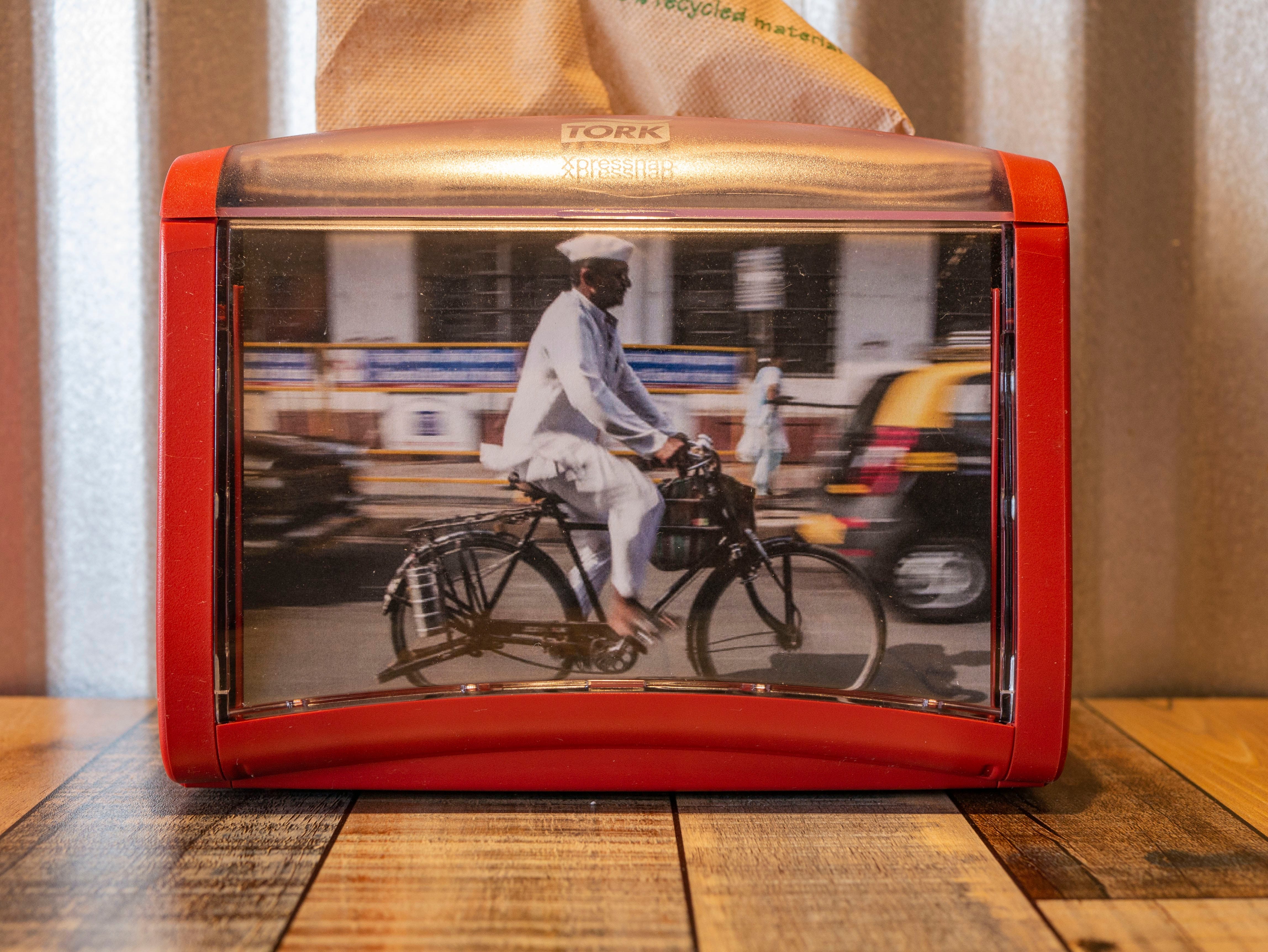 A napkin dispenser at Tiffin Box's West Palm Beach location features India's ubiquitous dabbawalas, the lunch delivery service that takes tiffin-boxed meals to workers.