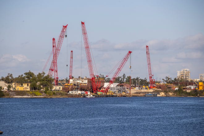The large cranes from Eastern Shipbuilding in Panama City loom over the waters of Watson Bayou Monday, February 22, 2021.