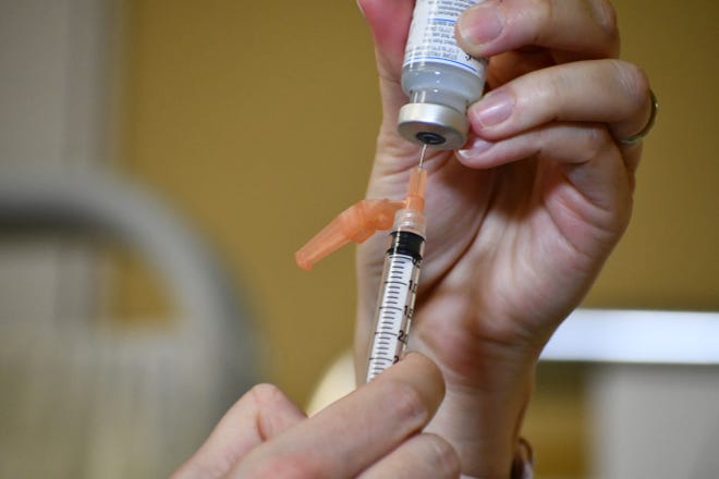 A health care provider prepares a dose of COVID-19 vaccine at an Aspirus facility