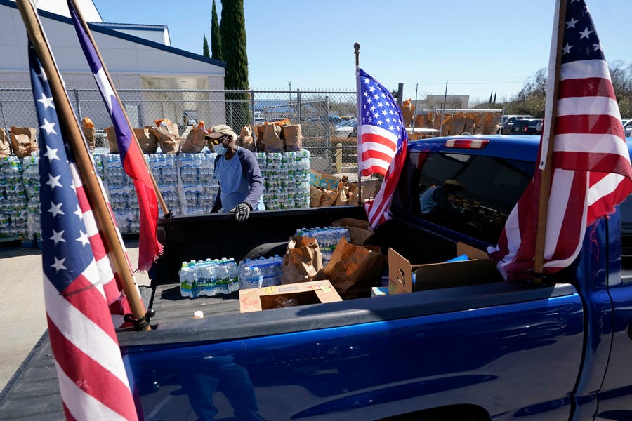 Food and water are loaded into the back of a pickup truck at a distribution site Monday, Feb. 22, 2021, in Houston. The city's boil water notice has been rescinded however many residents lack water at home due to broken pipes.