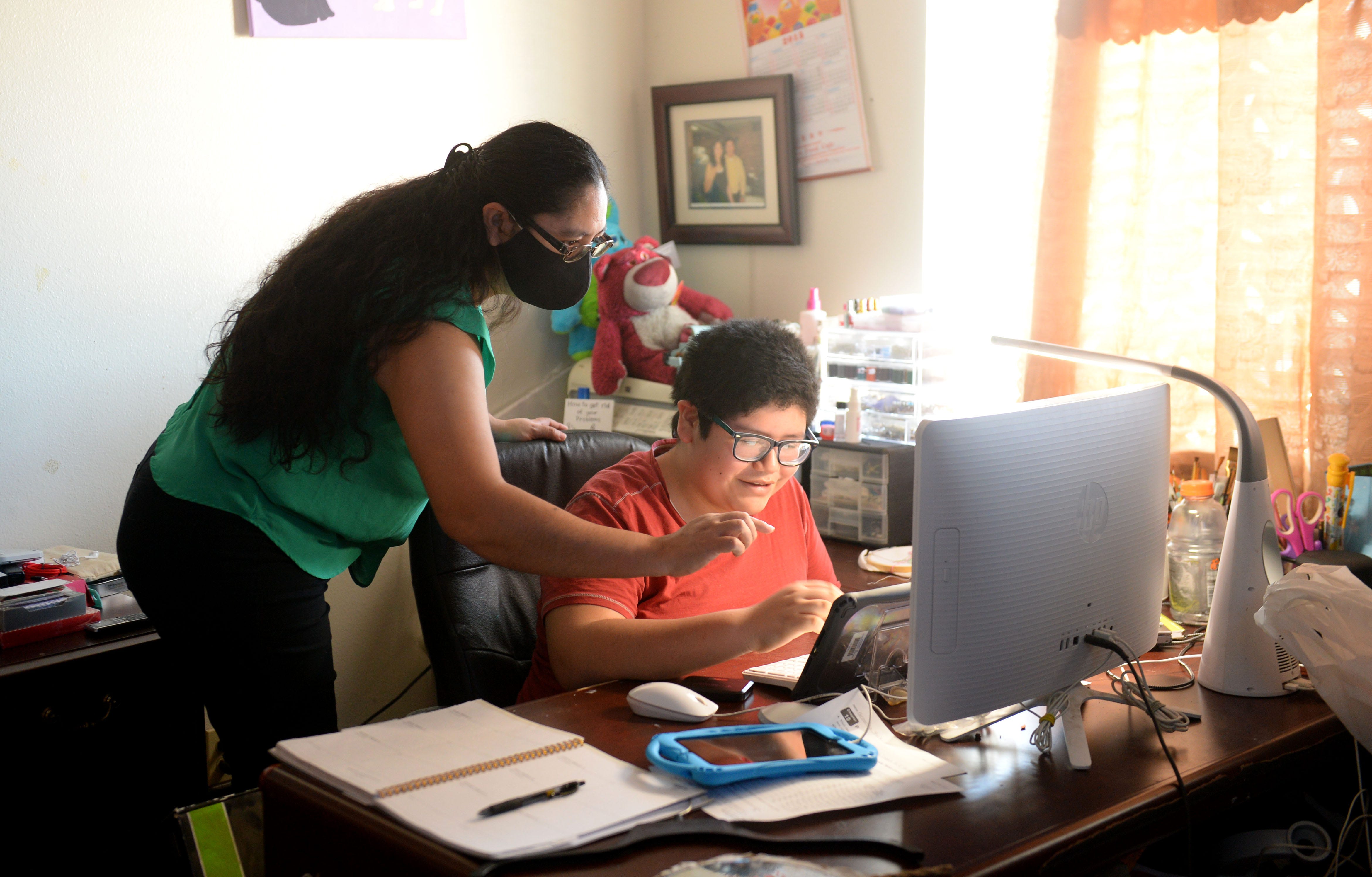 Jessica Vargas, left, helps her son Jorge Alberto Ruiz, 13, with his online classes on Monday, Feb. 22, 2021. Jorge is enrolled in special education classes and needs daily help from his mom.