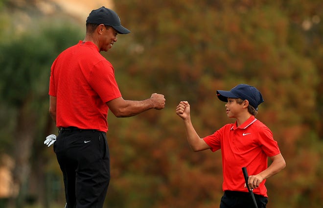 Tiger Woods of the United States and son Charlie Woods fist bump on the 18th hole during the final round of the PNC Championship at the Ritz Carlton Golf Club on Dec. 20, 2020 in Orlando, Fla. 