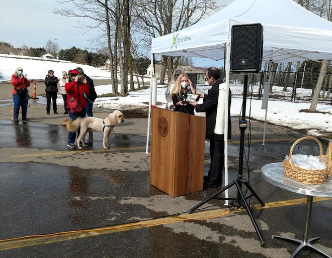 Green Mayor Gerard Neugebauer presents Dick Goddard's daughter, Kim Goddard, with a plaque commemorating the dedication of the Dick Goddard Dog Park at Ariss Park in Green on Wednesday.