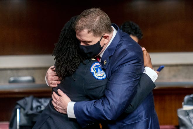 Former U.S. Capitol Police Chief Steven Sund, right, hugs Capitol Police Captain Carneysha Mendoza, left, before they testify before a Senate Homeland Security and Governmental Affairs & Senate Rules and Administration joint hearing on Capitol Hill, Washington, Tuesday, Feb. 23, 2021, to examine the January 6th attack on the Capitol. (AP Photo/Andrew Harnik, Pool)