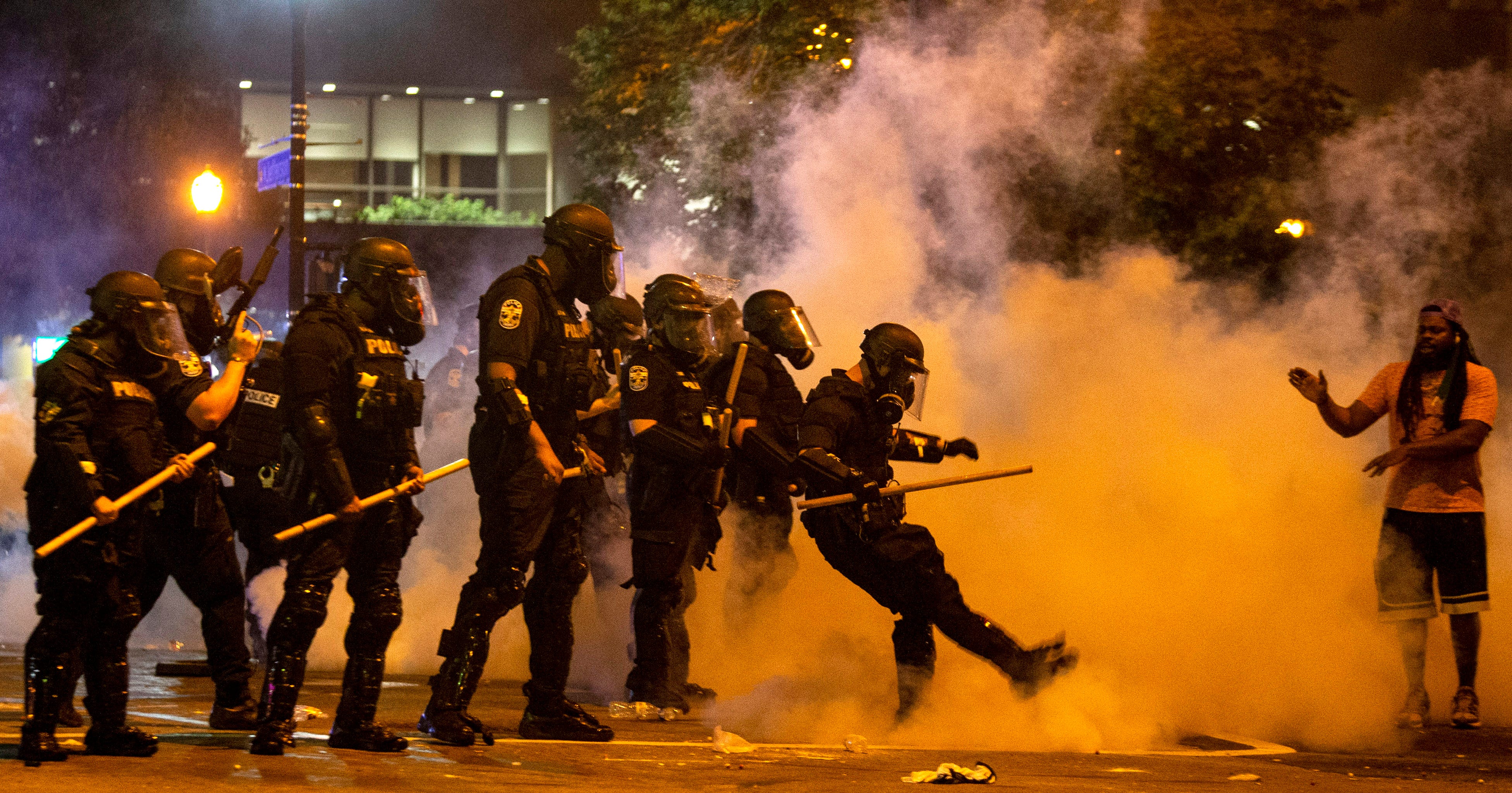 Scenes from a protest in downtown Louisville over the shooting of Breonna Taylor by Louisville police. A police officer kicks a tear gas canister back towards protesters after it was thrown past the police. May 28, 2020